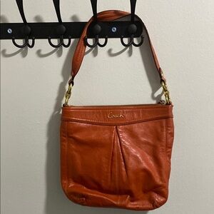 Orange leather coach bag with matching wallet